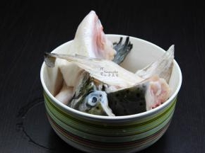 三文鱼头解冻，洗净去鱼鳃，切块放盐、油、料酒、鸡粉、生抽、鱼露腌制十分钟；