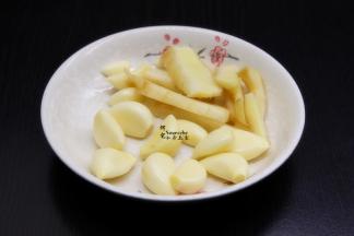 利用鱼头腌制的时间，剥蒜、生姜洗净切片、香葱切好备用；