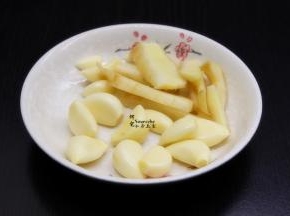 利用鱼头腌制的时间，剥蒜、生姜洗净切片、香葱切好备用；