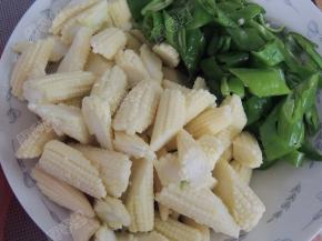 将玉米笋剥去外壳斜切成段，青椒切片