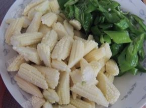 将玉米笋剥去外壳斜切成段，青椒切片