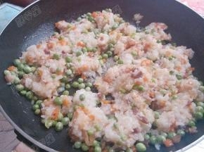 腊肉、胡萝卜、青豆切粒放入热油锅中翻炒，加入蒸熟的糯米饭翻炒均匀调味就可以做馅了