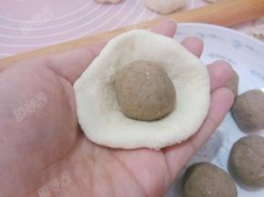 取一份面团擀成圆片，放入入豆沙球