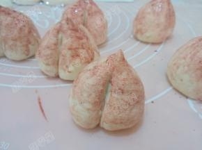 用刷子蘸红曲粉水刷在寿桃生坯上