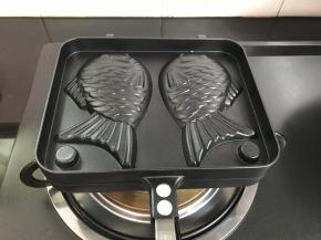 稠鱼烧模具放燃气灶上加热。