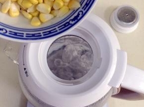 待水烧开，把剥好的玉米粒倒入壶内。
