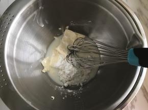 奶油奶酪加细砂糖及50克牛奶隔热水用手动打蛋器搅拌至无颗粒状。