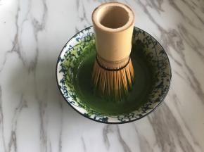 剩余50克牛奶隔水加热到60度，倒入抹茶粉中，用茶筅顺着一个方向打匀。