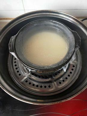 将碗锅盖上保鲜膜放入蒸锅盖上盖子，先蒸五，六分钟。