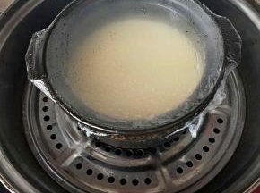 将碗锅盖上保鲜膜放入蒸锅盖上盖子，先蒸五，六分钟。