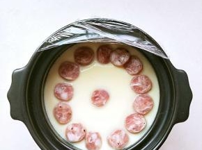 碗锅端起来有轻微晃动就行，放入切片的鲜肉肠。继续蒸4.5分钟。