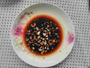 盘子中放入适量的盐，生抽，大蒜剁成蒜末放入，把油烧热倒入盘子中滋啦一下