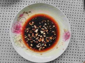 盘子中放入适量的盐，生抽，大蒜剁成蒜末放入，把油烧热倒入盘子中滋啦一下