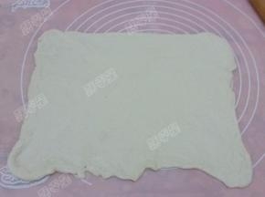 醒发好的面团重新揉匀，擀成大的方形薄片