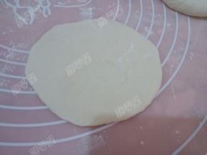 取一份剂子按扁擀成圆形薄饼，里厚外簿，在不会破的前提下，面越薄越好吃