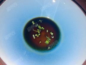 碗中放入猪油，加入酱油和葱花，浇入一勺沸腾的汤