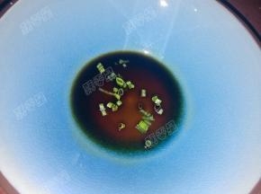 碗中放入猪油，加入酱油和葱花，浇入一勺沸腾的汤