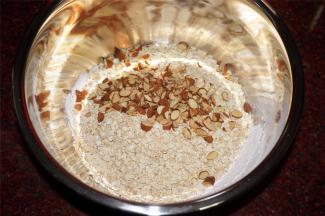 将低筋面粉筛入，然后加入燕麦片，切碎的杏仁粒。