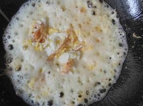 然后用铲子把鸡蛋搅散，翻炒一下