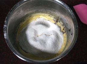 筛入100克低筋面粉、2克泡打粉、1克盐，搅拌均匀。