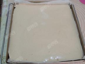 将蛋糕糊倒入烤盘中，用刮刀抹平并震出气泡