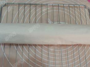 然后用擀面杖辅助，用另一张油纸卷起来，冷却定型后切成段