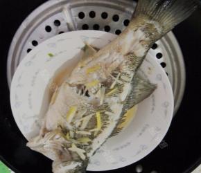 蒸好的鲈鱼取出，拣去葱姜