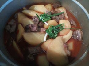 把牛肉土豆放到高压锅，再放两个葱，山楂少许盖上盖子，上汽以后，大火再煮8分钟（土豆块比较大，所以多煮了一点时间，）