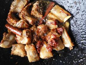 再放入排骨，翻炒均匀后，再加入红油豆瓣酱翻炒均匀。放入姜片，花椒，桂皮，八角等香料。