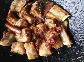 再放入排骨，翻炒均匀后，再加入红油豆瓣酱翻炒均匀。放入姜片，花椒，桂皮，八角等香料。