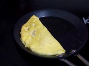 用筷子掀起一侧的蛋皮包过来，贴合在一起即可