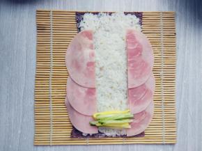 将黄瓜和鸡蛋、火腿片、米饭和紫菜如图摆好。米饭要在紫菜上铺平压实，卷的时候才不会散