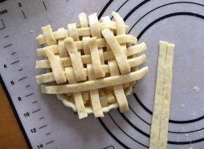 将剩余的派皮擀成薄片，用刀切成小长条，，在派盘表面编织出交叉的网格