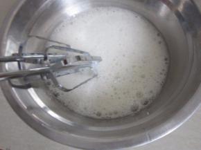 柠檬滴入蛋白，用打蛋器打至粗泡。