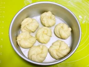 模具底下铺油纸，将卷好的花朵均匀的摆上，二次发酵半个小时，之后表层均匀的刷上全蛋液