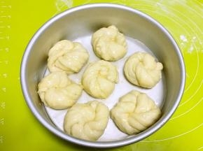 模具底下铺油纸，将卷好的花朵均匀的摆上，二次发酵半个小时，之后表层均匀的刷上全蛋液