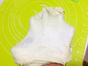 大约揉20分钟，面团没那么粘手，可以撑出简单的膜，加黄油，再揉十分钟