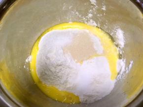 将面粉倒入盆内，加入全蛋液，砂糖，盐跟酵母分至面粉的两旁放