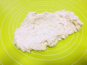 倒入乳清活成面团，放到揉面垫上一直向前推揉，因为面粉的吸水性不同，乳清建议先保留15克