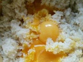 鸡蛋蛋白蛋黄分离，蛋黄放入米饭中，搅拌均匀 。