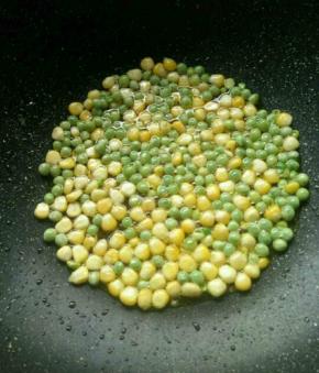 热锅放油，先放豌豆粒，再放玉米粒适当炒一下。