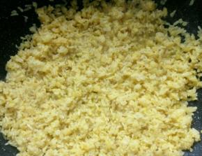 锅里再次放少量油加热，放入米饭翻炒，耐心翻炒，翻炒至蛋液全部附在米粒上。