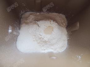 加入高筋面粉，在角落放入盐和糖，面粉中间趴窝放入酵母粉，开启揉面程序，十分钟后放入黄油，继续开启和面程序将面团揉至扩展阶段