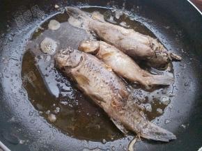 平底锅放入油，将小鲫鱼放入锅中煎至两面酥黄