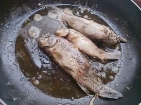 平底锅放入油，将小鲫鱼放入锅中煎至两面酥黄