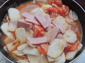 然后放入火腿片，煮至年糕变软