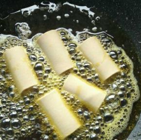 热锅加油烧热，放入豆皮卷开始炸