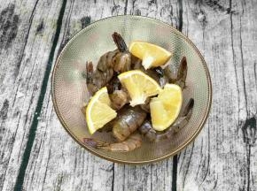 虾尾放几块柠檬拌匀，盖上保鲜膜，冰箱冷藏15分钟。