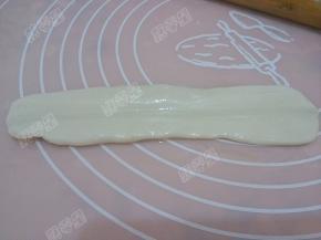 饧好的面团按扁，用擀面杖在中间压出痕迹