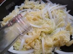 将菜叶翻炒至软后放入醋翻炒均匀